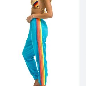 Aviator Nation blue sweatpants with neon rainbow stripes